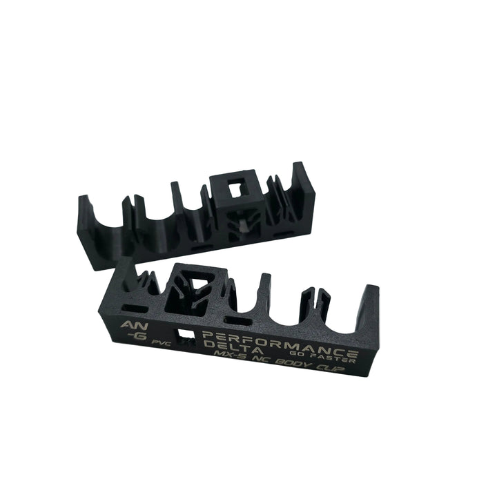 Two black nylon miata mx-5 NC car body clips on a light grey background, with one clip displaying &