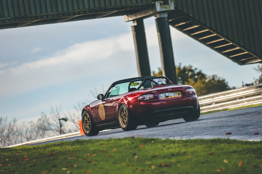 Mazda MX5 NC convertible car on a track with a bridge in the background