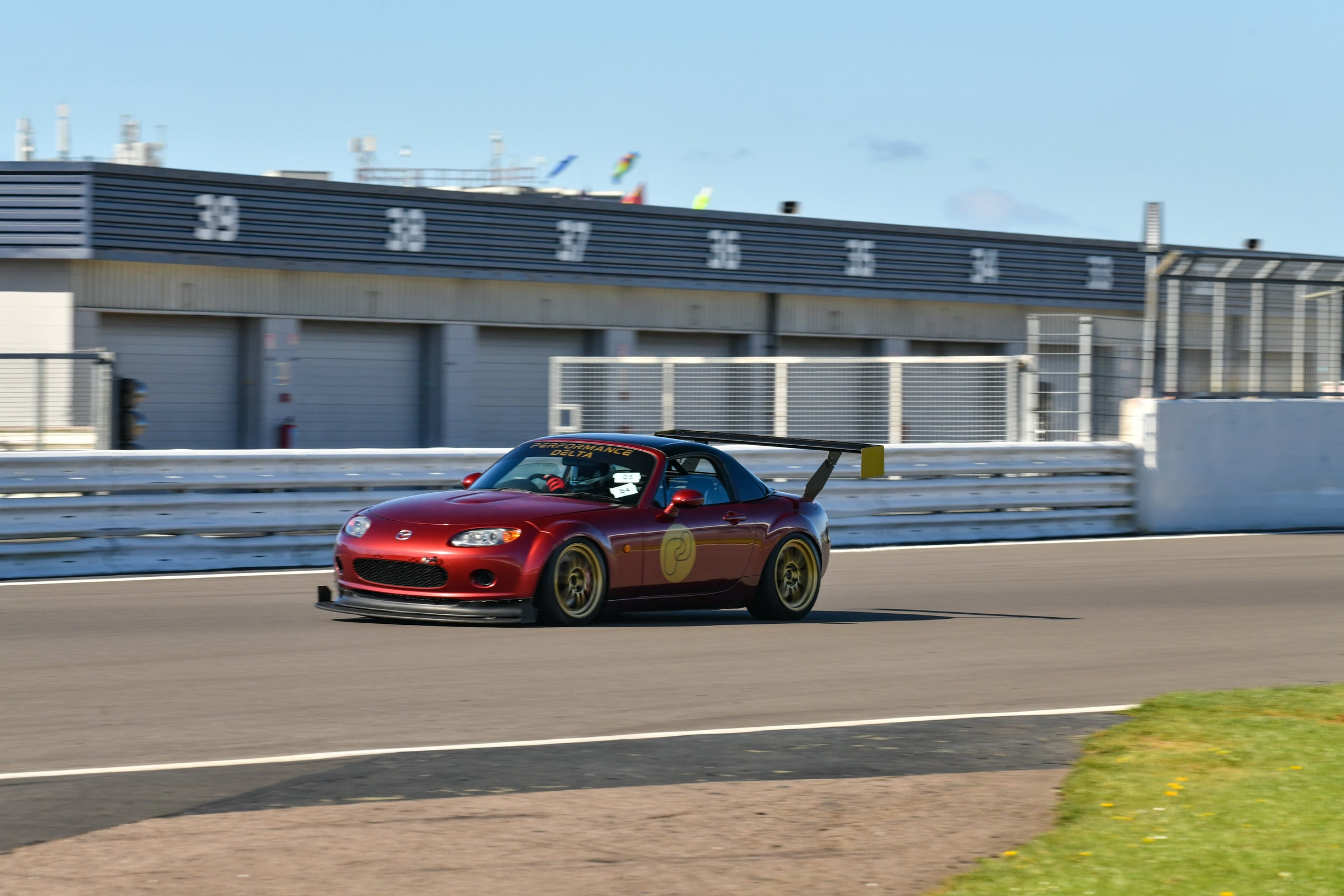 Mazda MX5 NC car on a race track with a clear sky